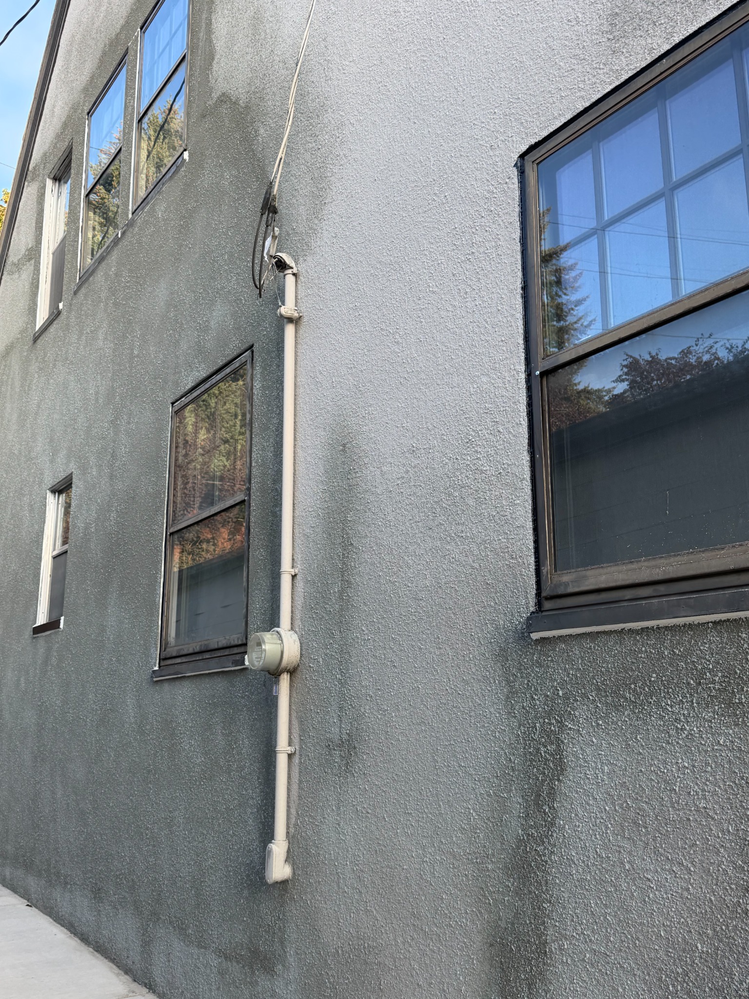 After repair: renewed stucco around the same window and electric meter, viewed from a different angle